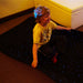 Young kid sitting on LED Fiber Optic Star Carpet with a smile having fun
