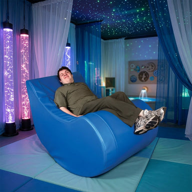 man sitting in a vibroacoustic chair in a sensory room